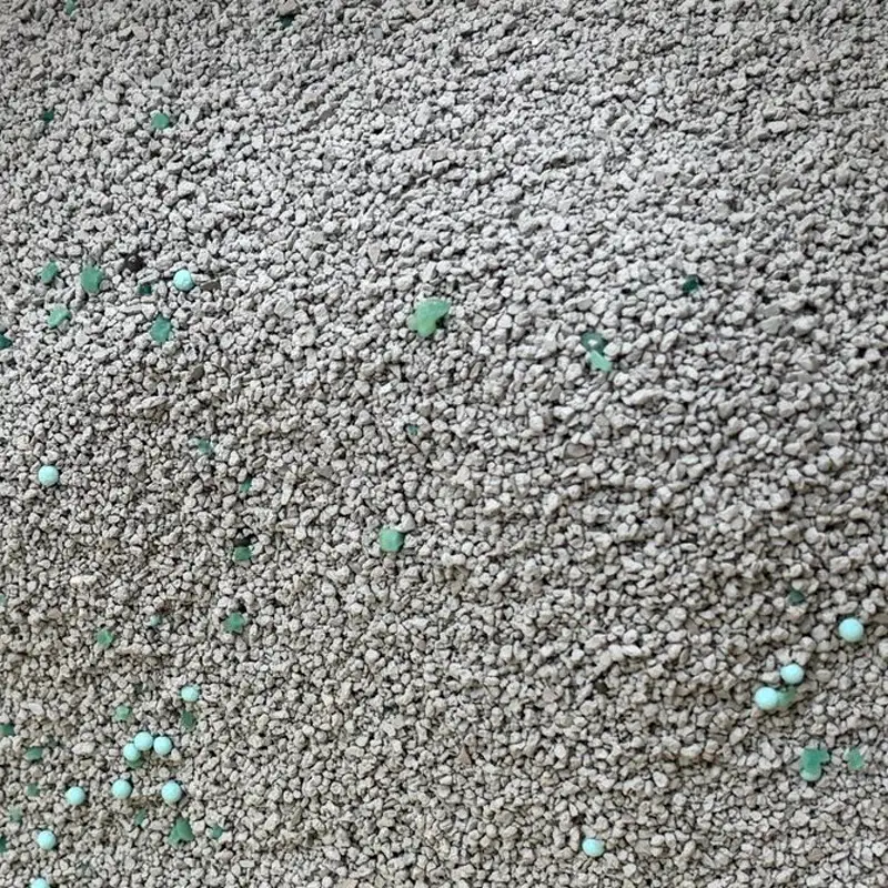 bentonite cat litter with visible green odorless mixed particles for formula differentiation